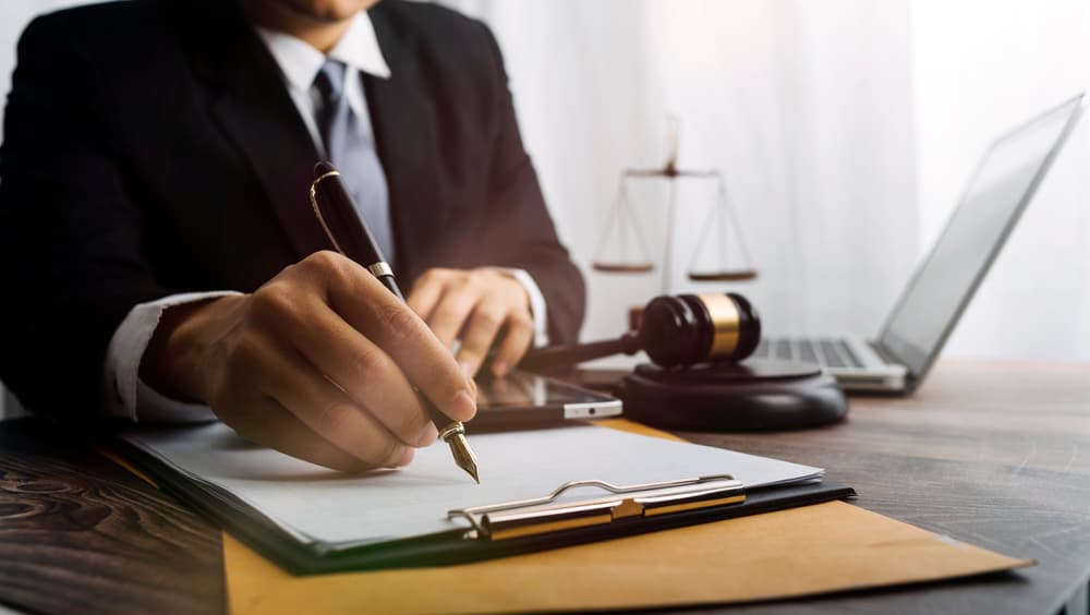 Male judge in a courtroom on a wooden table, with a male lawyer working in an office. Represents justice, legal advice, and the legal system.