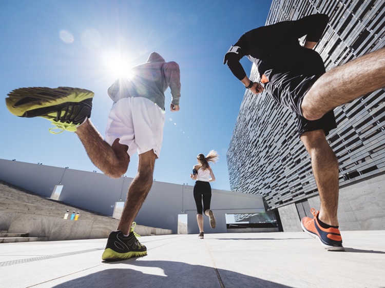 three friends athletes jogging in a modern building district