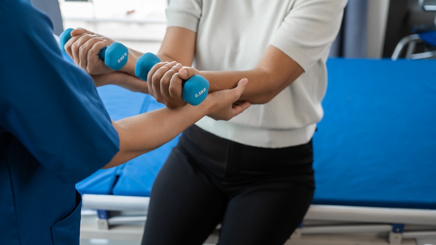 patient using weights for occupational therapy for long term injury recovery