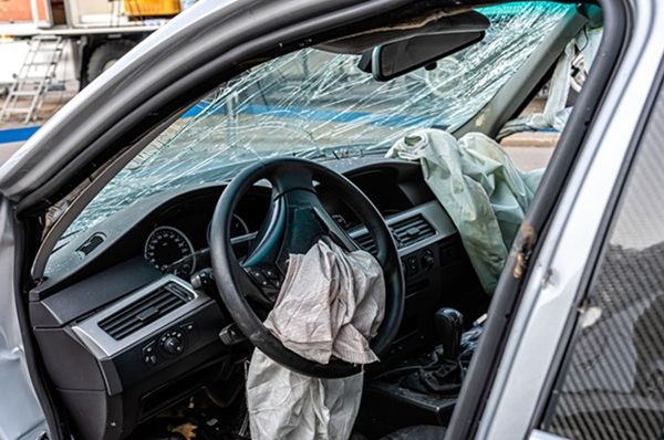 damaged vehicle closeup after a heavy crash, car wreck, exploded airbag, broken windshield